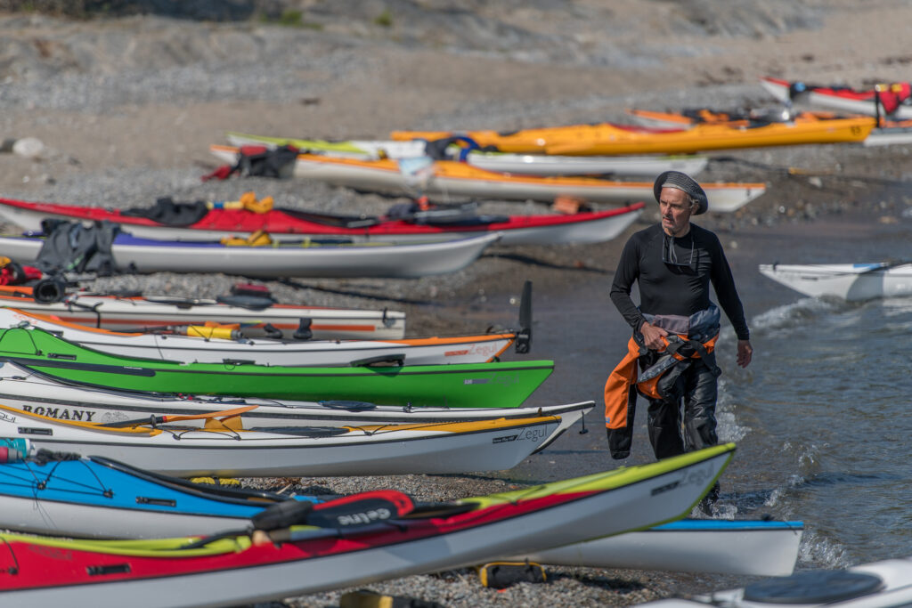 Francois walking along the beach, bu the kayaks